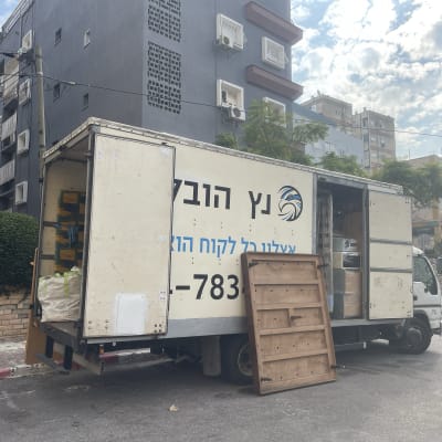 משאית הובלה פתוחה עם רהיטים וארגזים