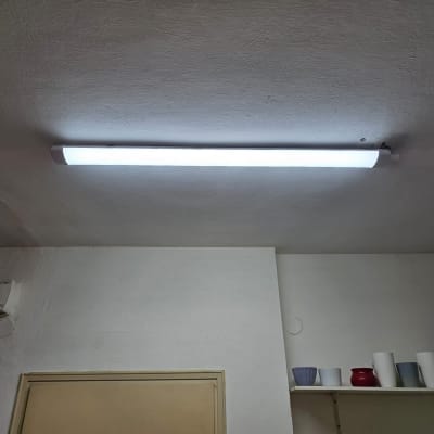 מנורת פלורסנט מותקנת על תקרה לבנה