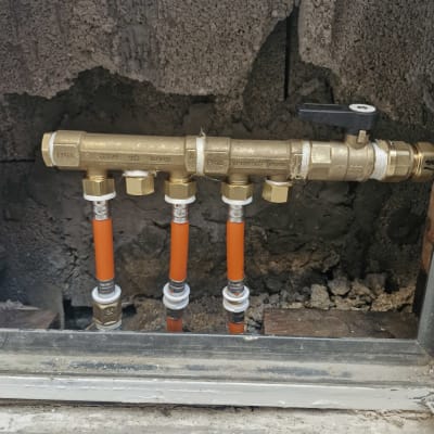 צינורות פלסטיק כתומים מחוברים לברזי מתכת בקיר