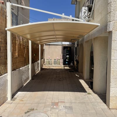 סככה מותקנת בחצר עם קיר אבן