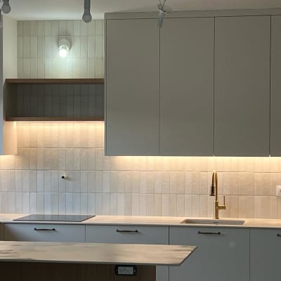 מטבח משופץ עם ארונות לבנים וברז זהב