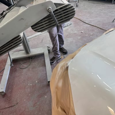 תהליך ייבוש צבע לרכב עם מנורת אינפרא אדום במוסך פחחות