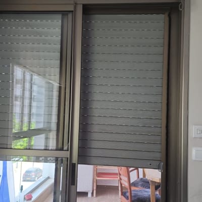 תריסים סגורים על חלון זכוכית עם מסגרת מתכת