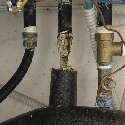 צינורות מחוברים לדוד שמש עם חלודה ונזילות