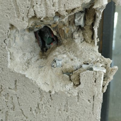 חוטי חשמל חשופים בקיר שבור