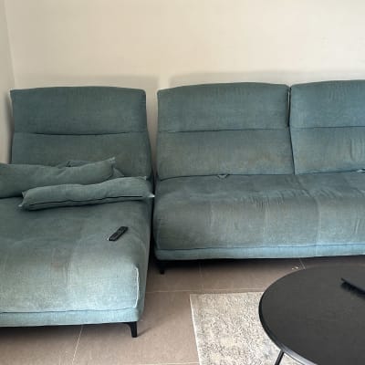 ספה כחולה עם כתמים ושלטים על המושב