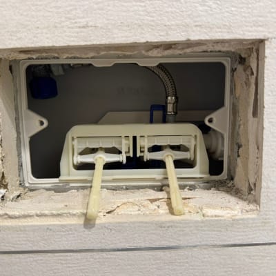 תמונה של מערכת אינסטלציה בקיר עם צינורות וחיבורים