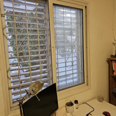 חלון עם תריסים וסורגי מתכת