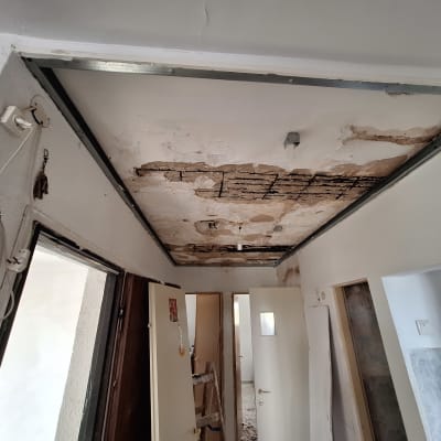 תקרת גבס פגומה עם סימני רטיבות ותיקונים