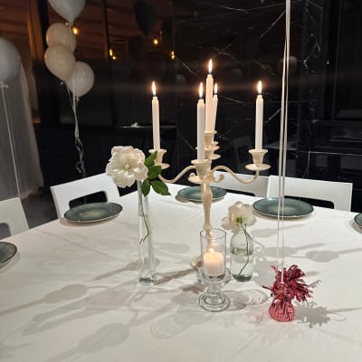 שולחן מעוצב עם נרות, פרחים ובלונים לאירוע