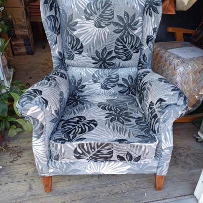 כורסה מרופדת בדוגמת עלים בשחור ולבן