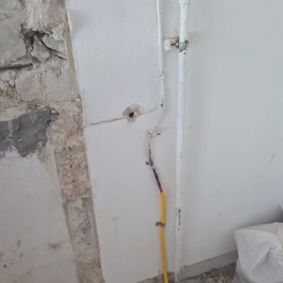 חוטים וצינורות בקיר עם תיקון טיח