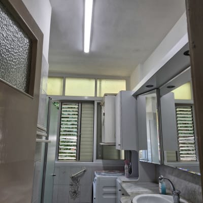 חדר אמבטיה עם כיור, מראה ומכונת כביסה