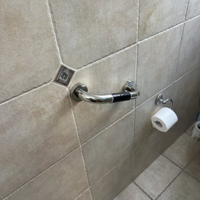 ידית אחיזה מותקנת על קיר אריחים בחדר אמבטיה
