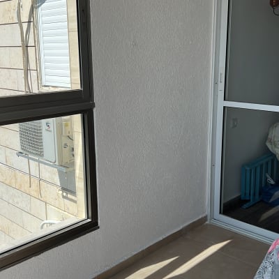 מרפסת עם קיר לבן צבוע וצל על הרצפה