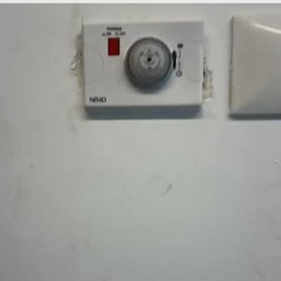 תרמוסטט על קיר לבן עם כפתור סיבובי