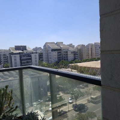 נוף עירוני עם דוקרנים נגד יונים על מעקה מרפסת