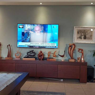 ציור מופשט עם דמויות על קיר בסלון