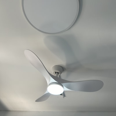 מאוורר תקרה עם תאורה מותקן על תקרה לבנה