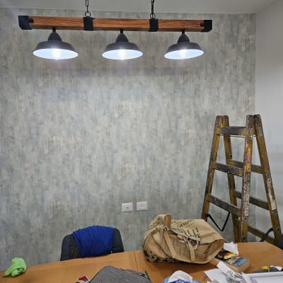 קיר עם טפט אפור, סולם ועבודות נייר על שולחן