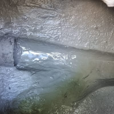 צינור מתכת בתוך בור עם חומר אפור