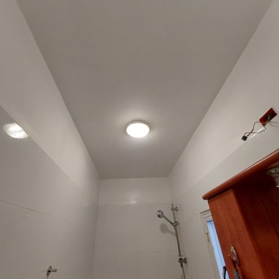 תקרה צבועה בלבן עם מנורה עגולה