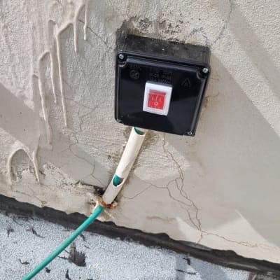 מתג חשמלי על קיר עם חוט ירוק