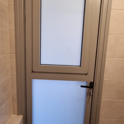 דלת אלומיניום עם זכוכית חלבית ומסגרת אפורה