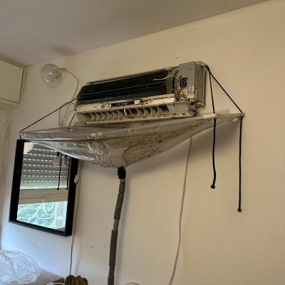 מזגן מפורק עם צינור ניקוז תלוי על הקיר