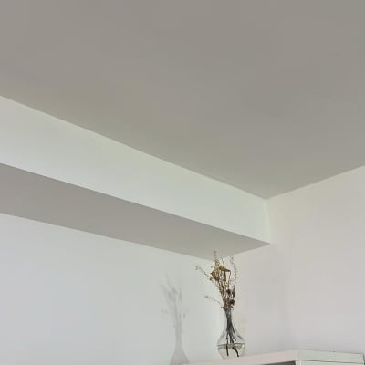 קיר גבס לבן עם מדף ופרחים באגרטל