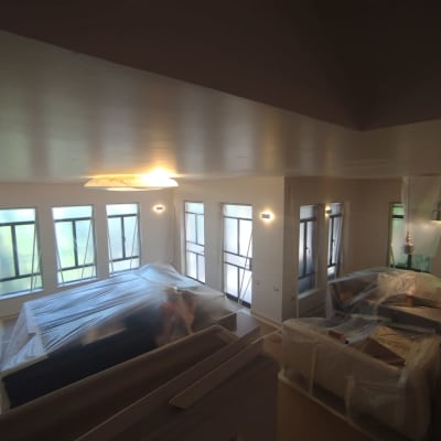 חדר עם רהיטים מכוסים בניילון לקראת צביעה