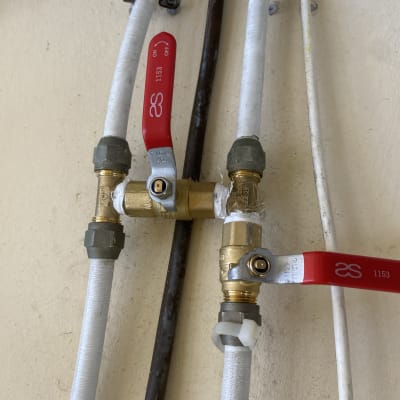 ברזי צנרת עם ידיות אדומות על קיר