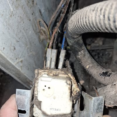 חוטים מחוברים לרכיב חשמלי במקרר מאובק