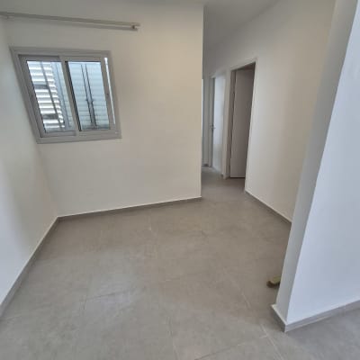 חדר עם רצפת אריחים חדשים וקירות צבועים בלבן