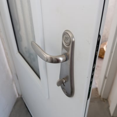 ידית דלת מתכתית על דלת לבנה