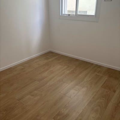 רצפת פרקט עץ בחדר ריק עם קיר לבן