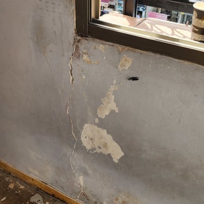 קיר מתקלף עם שפכטל על הרצפה