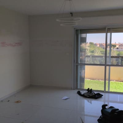 חדר ריק עם חלון גדול וכלים על הרצפה