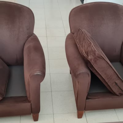 שני כורסאות חומות עם כריות על רצפה בהירה