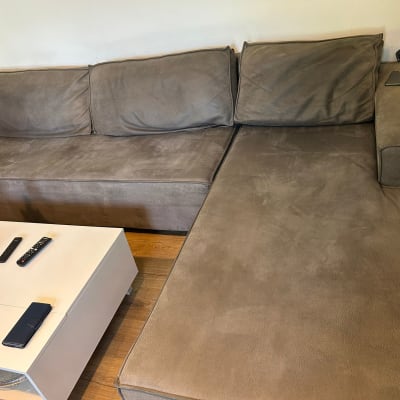 ספה חומה עם כריות על רצפת עץ