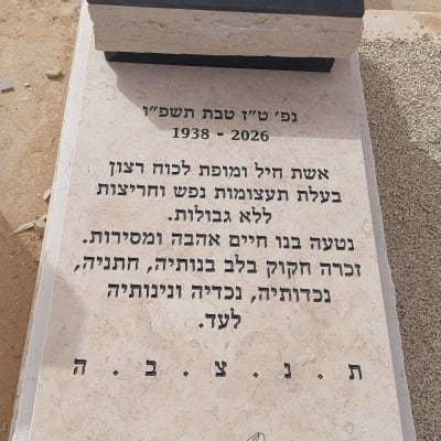 מצבה עם כיתוב בעברית ועיטור פרחים