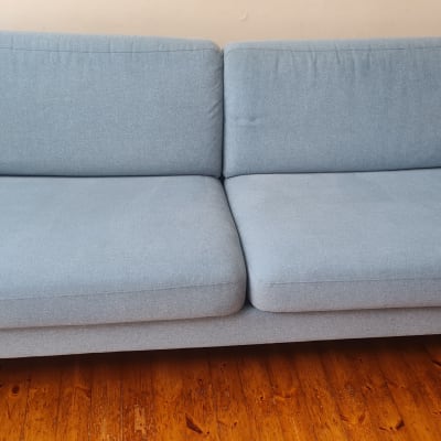 ספה כחולה על רצפת עץ