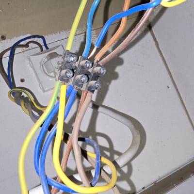 חוטי חשמל צבעוניים מחוברים לקופסת חיבורים