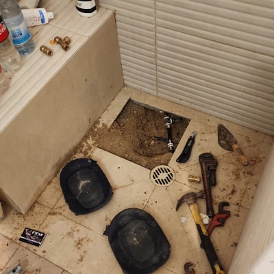 כלים לעבודת אינסטלציה, כולל מפתח צינורות ופטיש