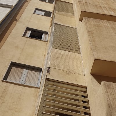 רשת מתוחה על קיר בניין למניעת כניסת יונים