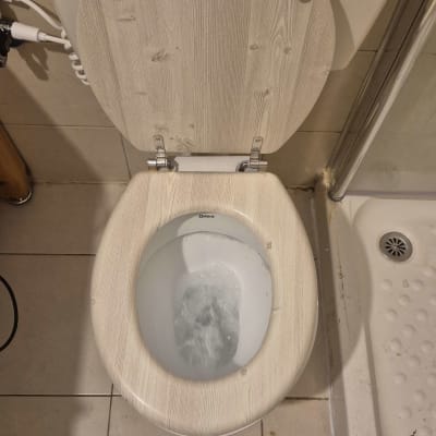 אסלה עם מכסה עץ ומים זורמים