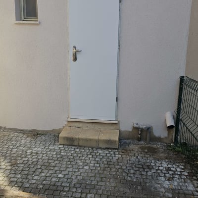 דלת לבנה עם ידית מתכת על קיר חיצוני