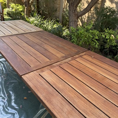 שולחן עץ בגינה עם עצים ברקע