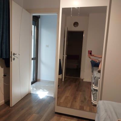 מראה גדולה בחדר עם רצפת עץ