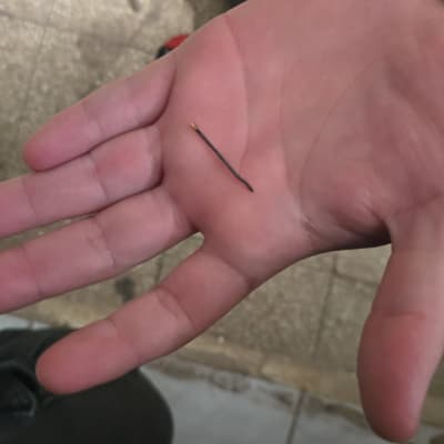 יד מחזיקה כלי קטן ליד מקדחה על הרצפה